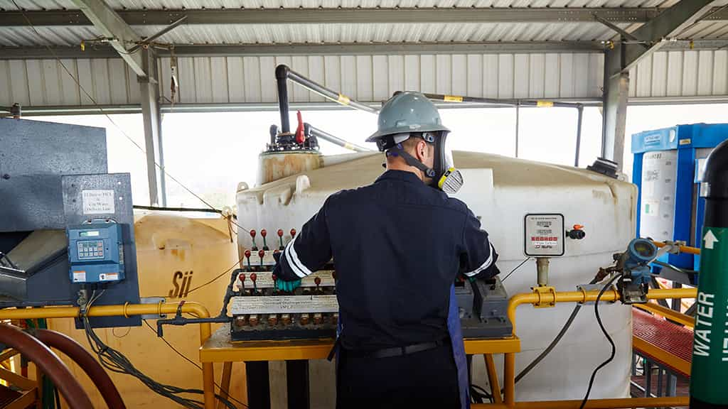 Man with gas mask inspecting equipment